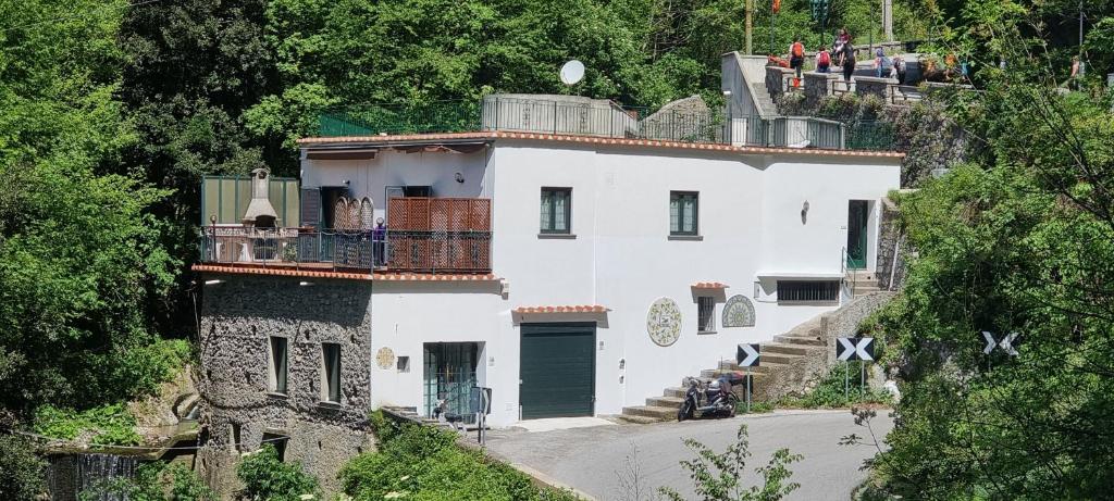 une grande maison blanche sur une colline avec des arbres dans l'établissement Casa Vacanze O'Mulin Ravello via fiume 2 incrocio Pontone, à Ravello