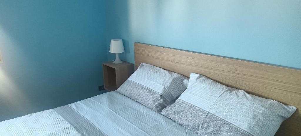 een blauwe slaapkamer met een bed met witte lakens en kussens bij Gian maria Vacanze in Altopascio