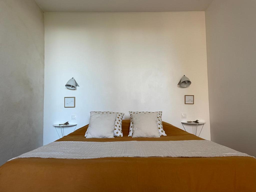 una camera da letto con un grande letto con due cuscini di Le Jardin Suspendu Vieux-Lyon - Option Garage a Lione