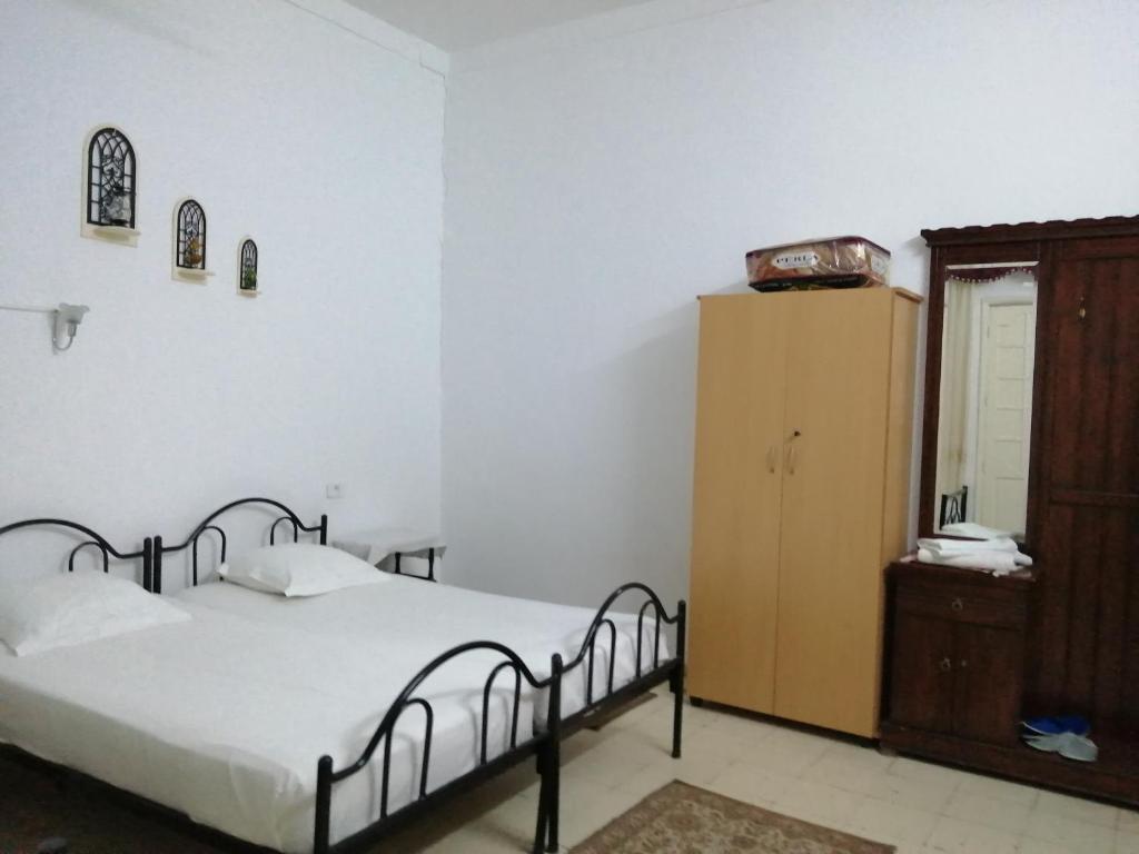 - une chambre avec un lit et une armoire en bois dans l'établissement Dar manena, à Kairouan