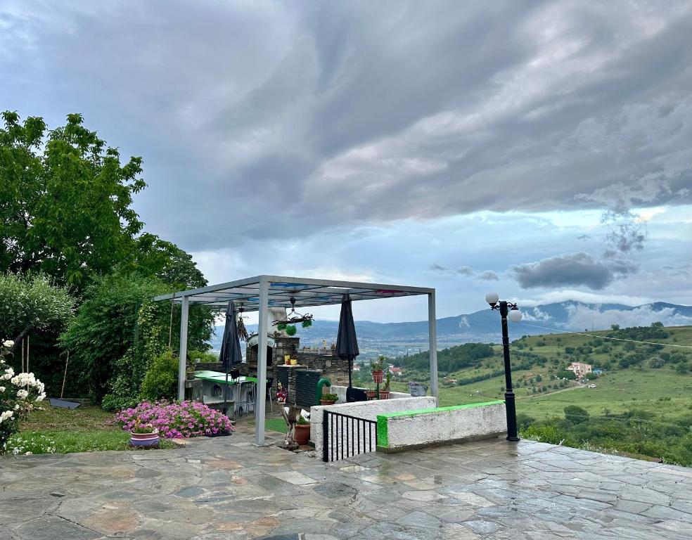 een prieel met een tafel en een parasol bij Archontiko Alexandros Luxury Suites in Kardiá