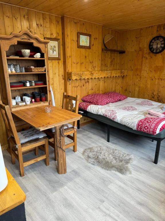 a bedroom with a bed and a table in a room at Apparemment cosy style savoyard in Bourg-Saint-Maurice