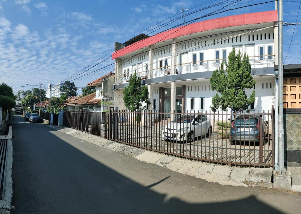 una valla con coches estacionados frente a un edificio en Hotel Residence 5 Syariah, en Bandung