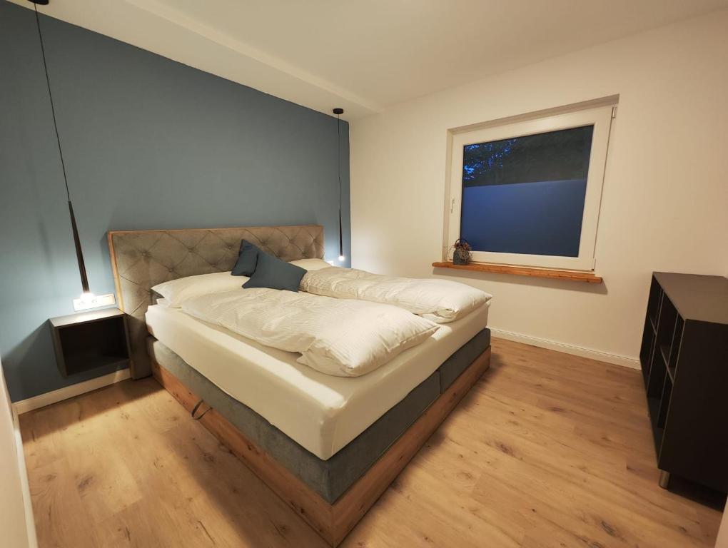 - une chambre avec un grand lit et une fenêtre dans l'établissement Ferienwohnung an der Nordsee, à Emden