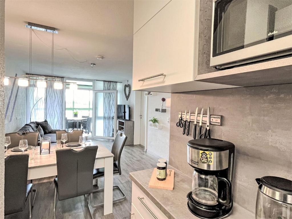 een keuken en een woonkamer met een tafel en stoelen bij Apartment Flieder - F 96 by Interhome in Dittishausen