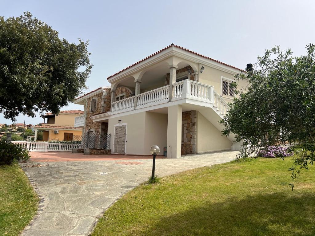 una grande casa bianca con balcone sul vialetto di Villa Maccioni a Budoni