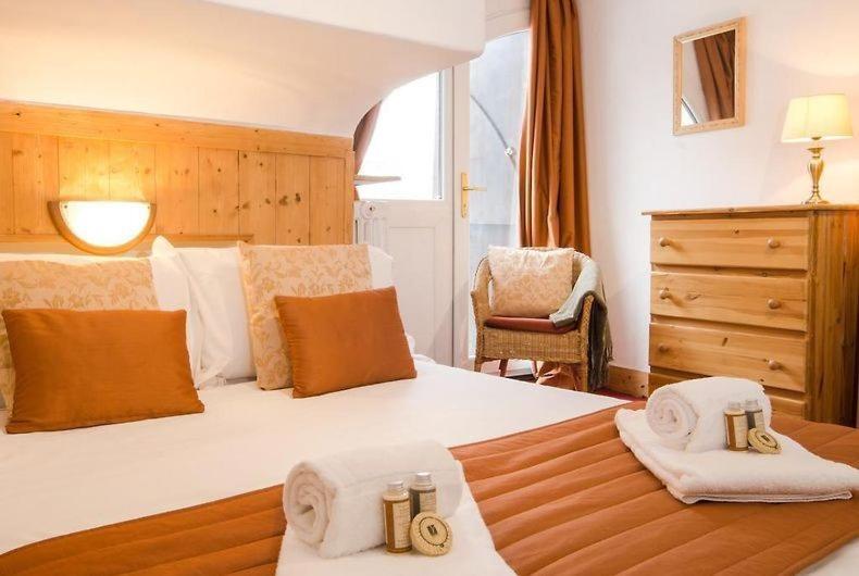 een slaapkamer met een groot bed en handdoeken bij Rond Point d Arbois in Megève