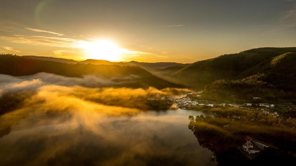 uma vista para um rio com o sol ao fundo em Reinado de Dom Dinis em Dornes