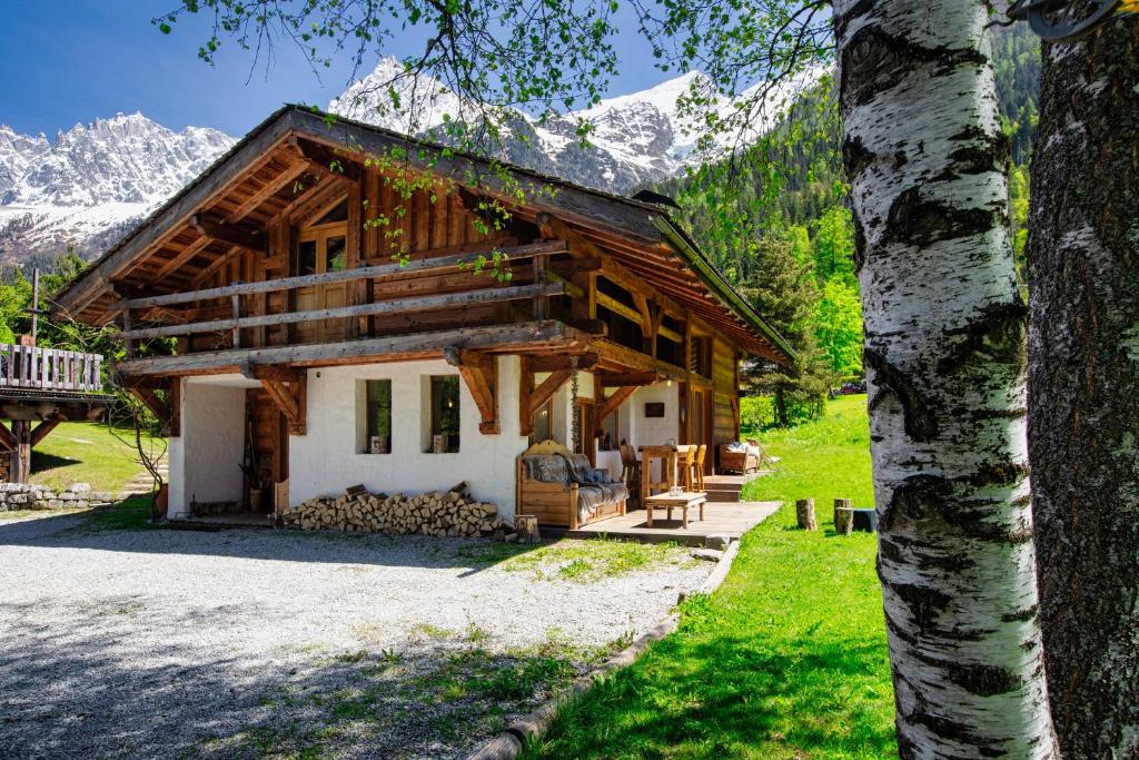 ein Blockhaus mit Bergen im Hintergrund in der Unterkunft Chalet Taconnaz - Warm & Cosy 3BR Chalet with Fireplace in Nature - By Cozee Rentals in Les Houches