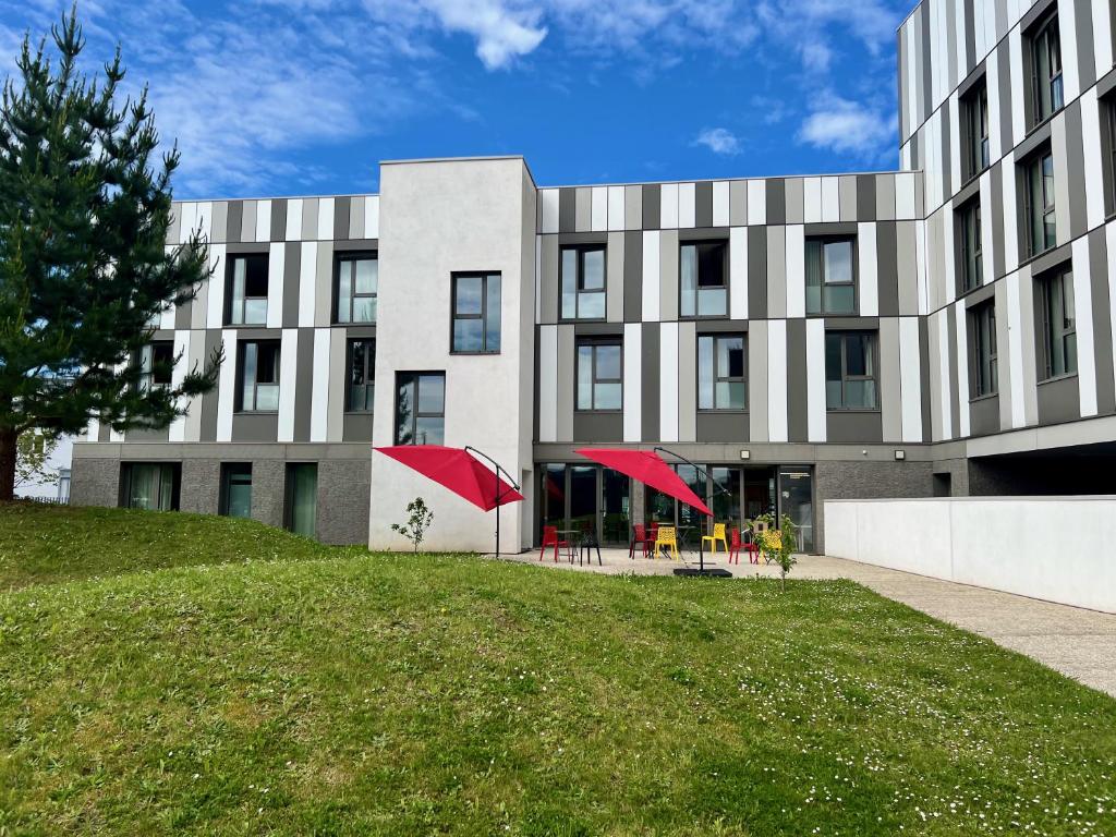 ein Gebäude mit grünem Rasen davor in der Unterkunft Premiere Classe Le Havre Centre-LES DOCKS in Le Havre