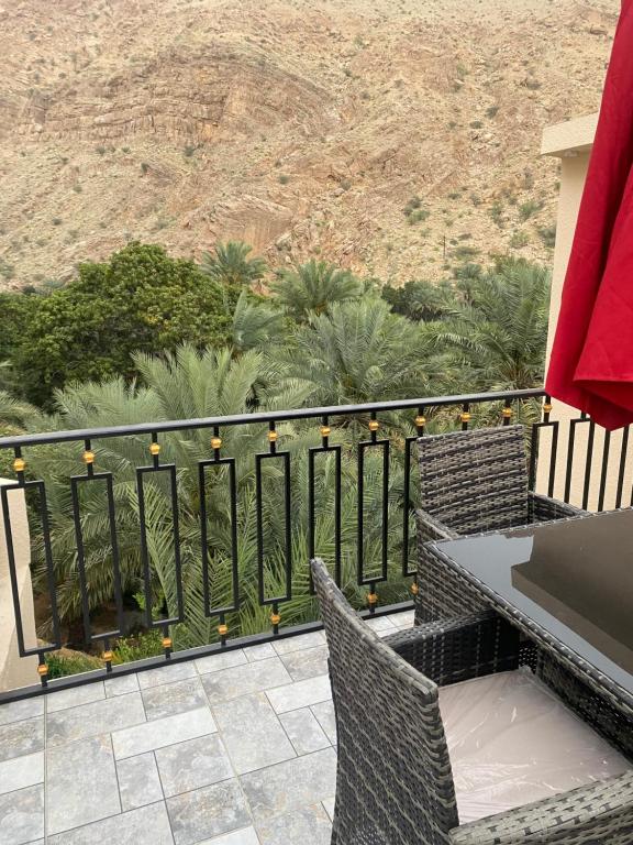 d'un balcon avec une table et des chaises donnant sur le désert. dans l'établissement WADI BANI KALED REST HOUSE, à Dawwah