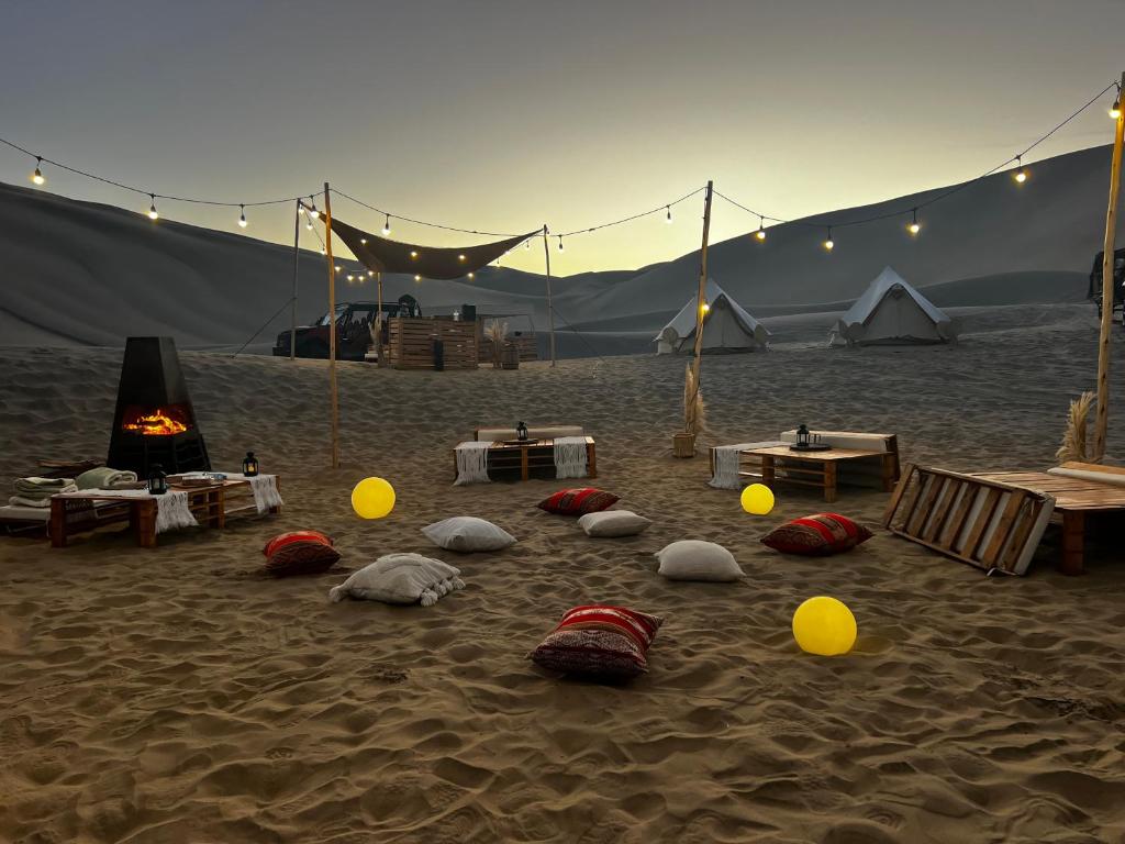 una playa con una tienda y unas pelotas en la arena en Duna Camp Huacachina, en Ica