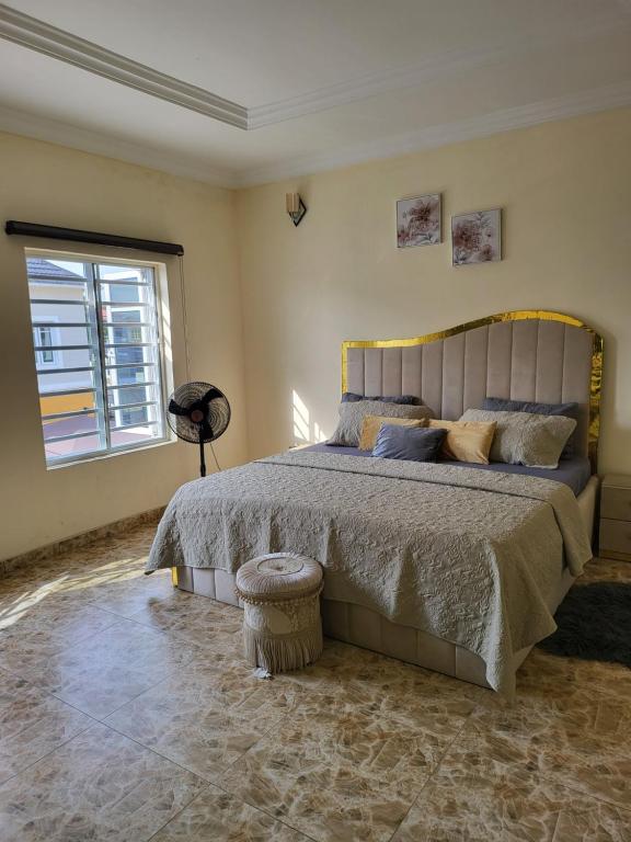 ein Schlafzimmer mit einem großen Bett und einem Fenster in der Unterkunft Dvyne Lux Home - Off Ikeja in Ikeja