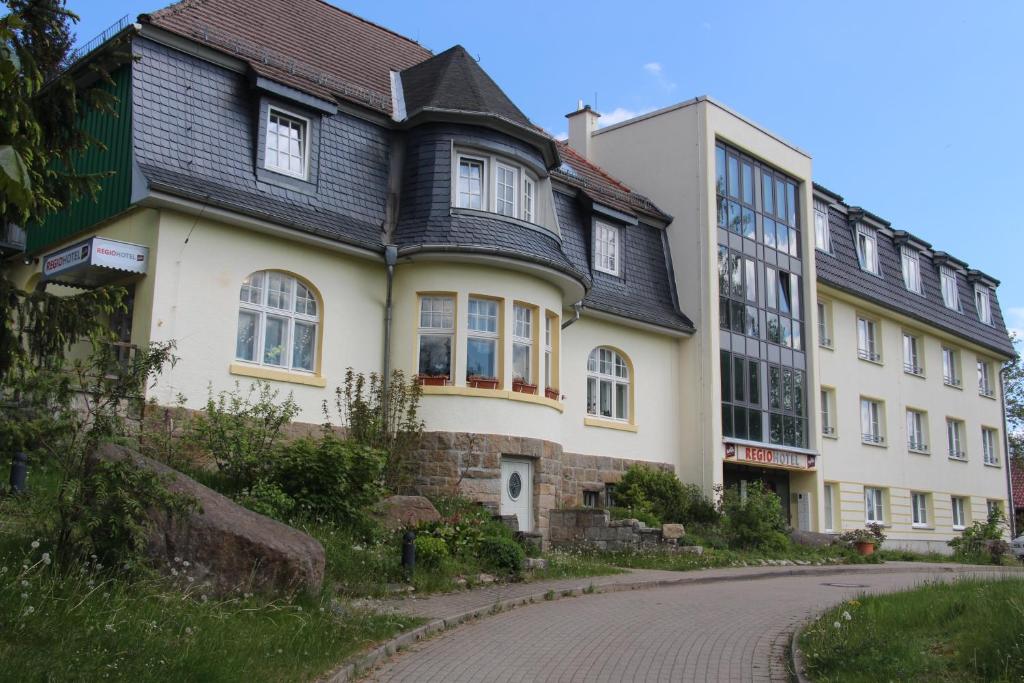 um grande edifício branco com um telhado preto em REGIOHOTEL Am Brocken Schierke em Schierke