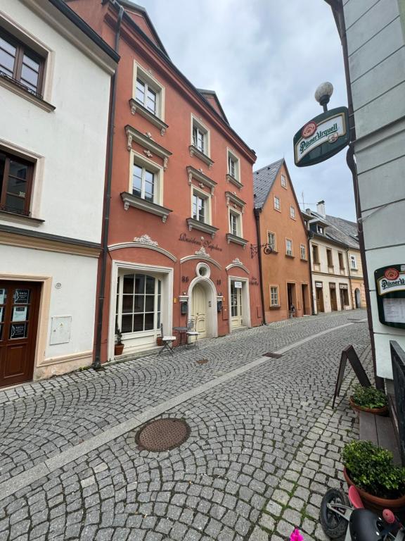 een geplaveide straat in een stad met gebouwen bij Rezidence Napoleon in Loket