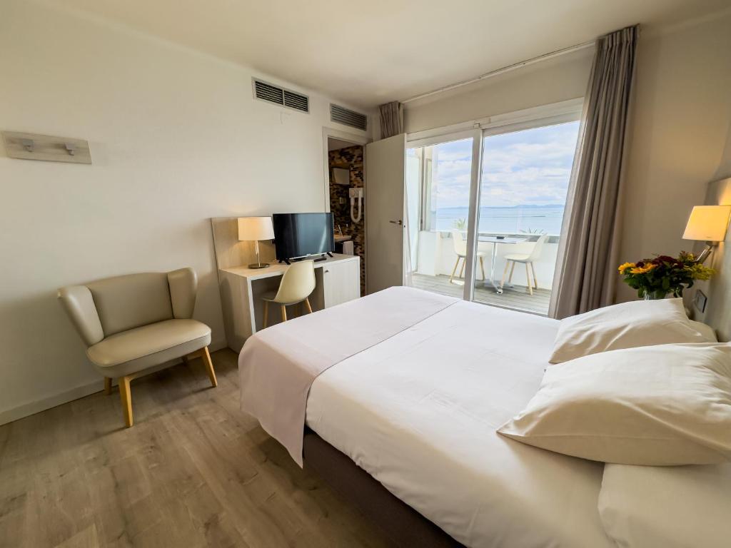 a hotel room with a bed and a chair and a window at Hotel Marina in Roses