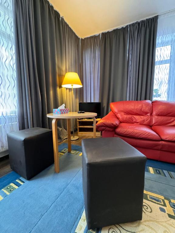 - un salon avec un canapé rouge et une table dans l'établissement Apartamenty Stary Rynek 18, à Łomża