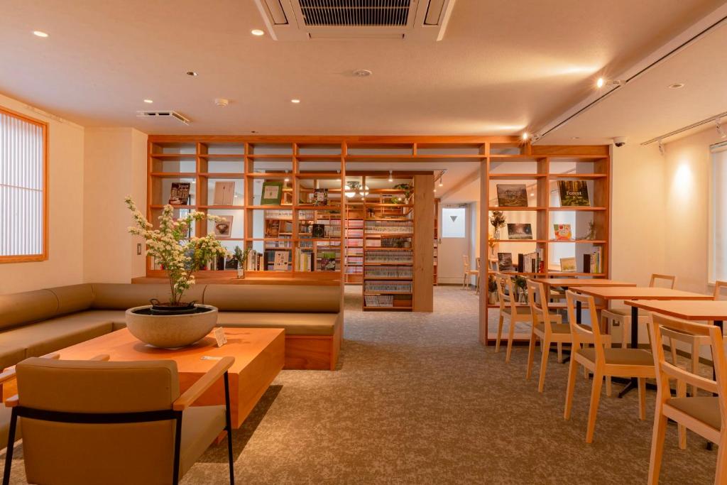 een restaurant met tafels en stoelen en een bibliotheek bij Matsumoto Tourist Hotel in Matsumoto