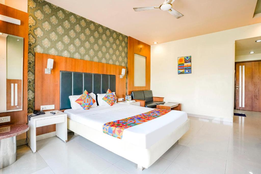 um quarto com uma grande cama branca num quarto em FabHotel Prime Devanshi Inn - Panvel em Kalamboli