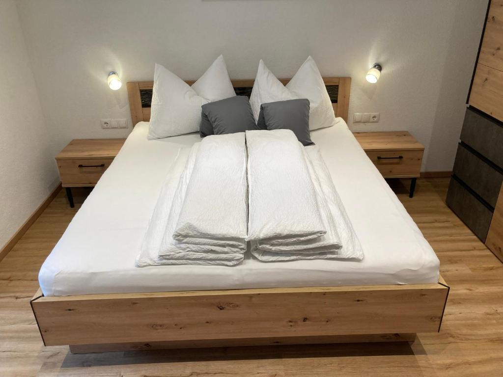 Elle comprend un grand lit avec des draps et des oreillers blancs. dans l'établissement Ferienwohnung Kirschner in Unter Tösens inkl SUPER SOMMER CARD, à Serfaus