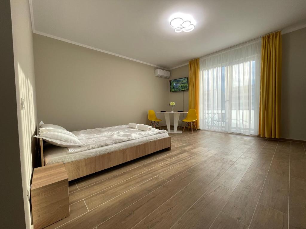 sypialnia z łóżkiem i stołem w obiekcie Apartament R&R w mieście Giroc