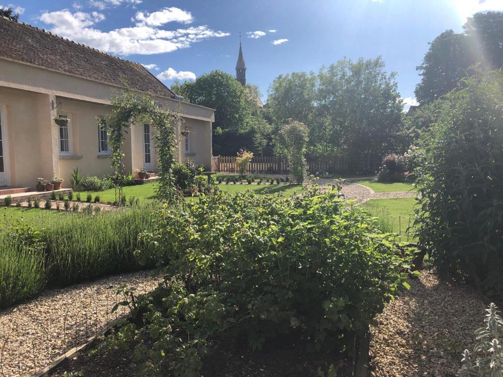 um jardim com uma casa e uma igreja em Riverside Lodge em Chablis