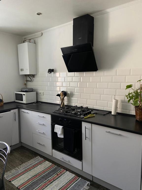 a kitchen with a black and white stove top oven at Квартира у Старому місті in Kamianets-Podilskyi