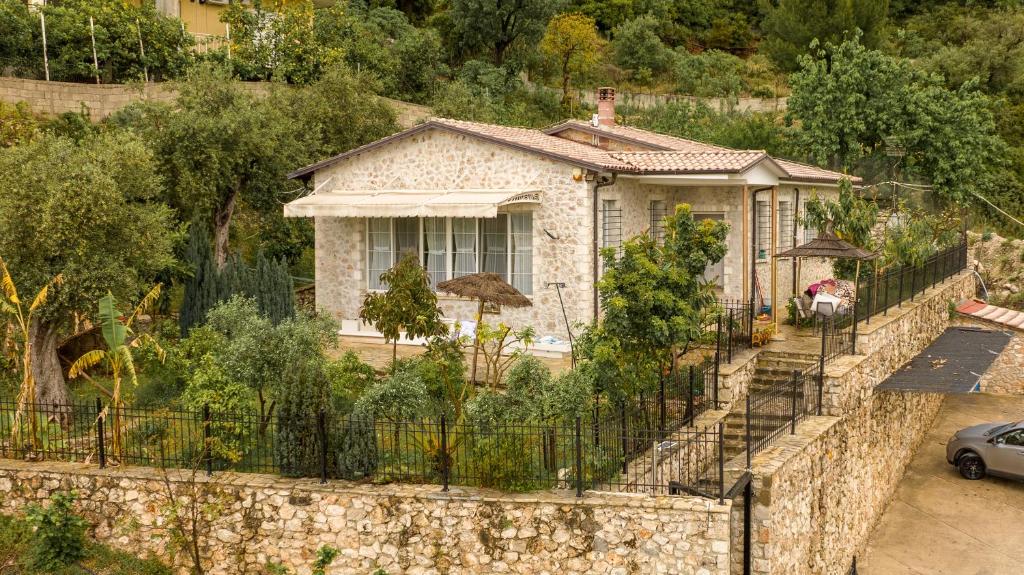 een huis achter een stenen muur met een hek bij Vila Agora in Dhërmi