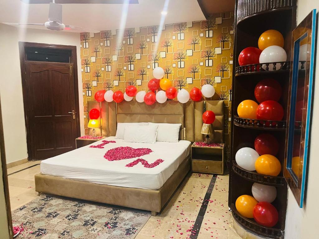 una camera da letto con un letto con palloncini appesi al muro di Madcrew Lodge a Islamabad