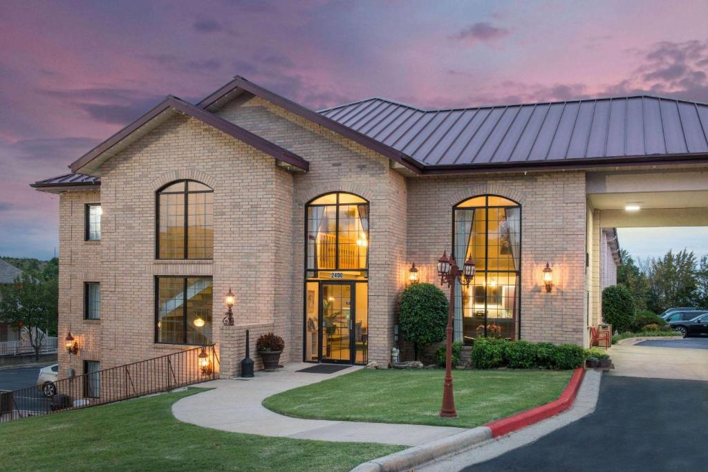 een stenen huis met een zwart dak bij Super 8 by Wyndham Branson Andy Williams Theater in Branson