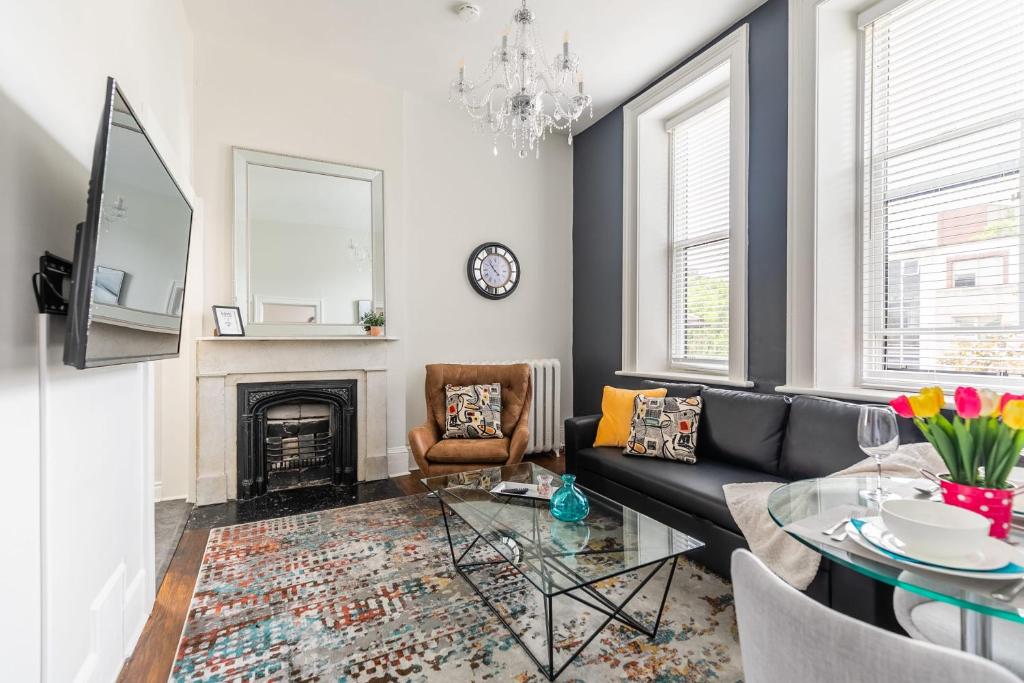 a living room with a black couch and a fireplace at Apartment in the James South Neighborhood in Hamilton