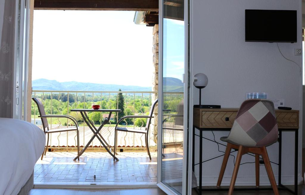 Schlafzimmer mit einem Bett und Blick auf einen Balkon in der Unterkunft Hôtel de Vacances de la Vignasse in Chandolas