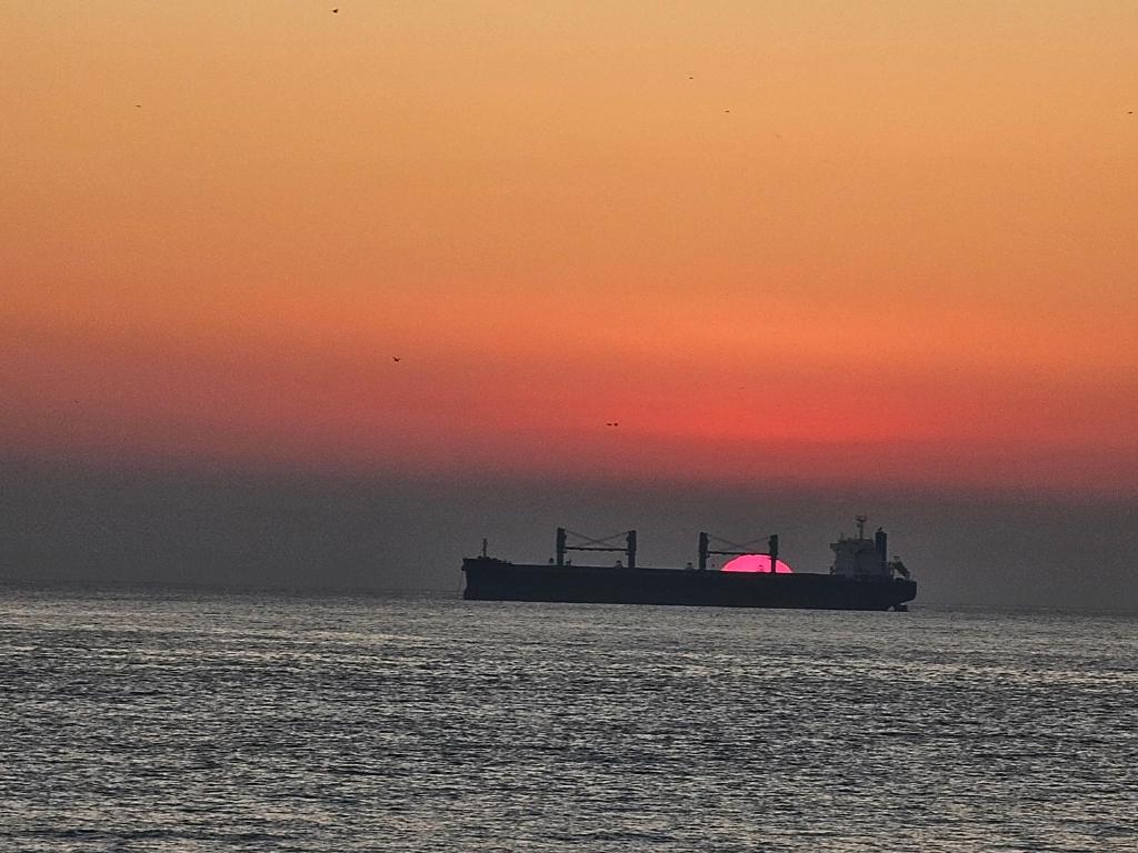 een grote boot in de oceaan bij zonsondergang bij Departamento Frente al Mar in Viña del Mar