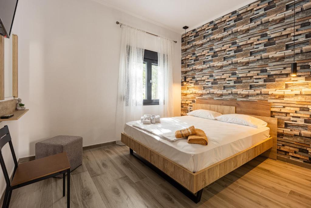 a bedroom with a large bed and a brick wall at MonteCasa in Epanomi