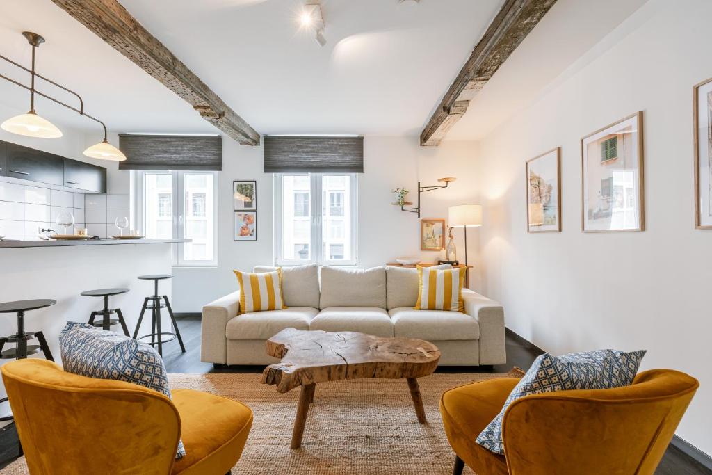 a living room with a couch and chairs and a table at Chic Cityscape Apartment Ghent in Ghent