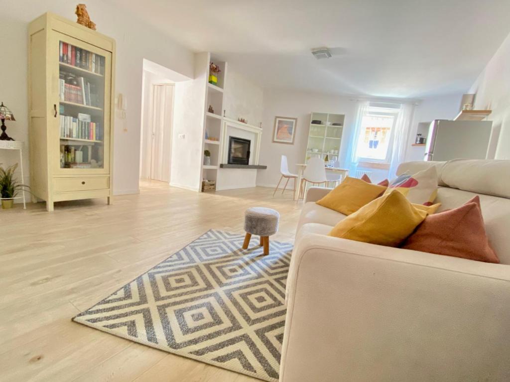 a living room with a white couch and a rug at La casa di Ursula in Toscolano Maderno