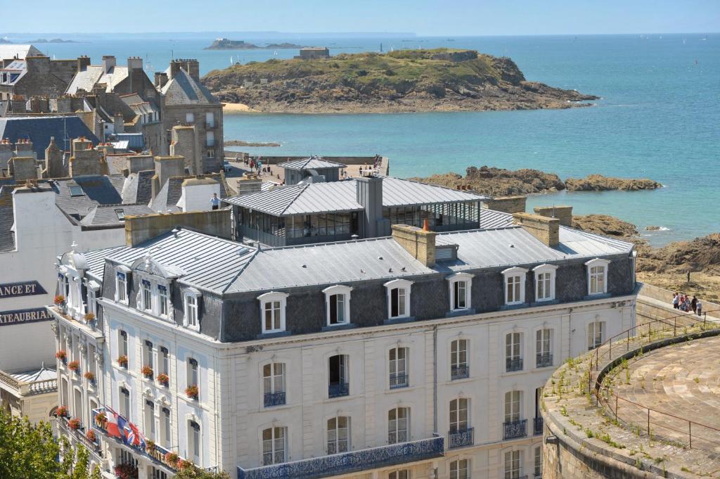 un gran edificio blanco junto al océano en Hôtel France et Chateaubriand, en Saint-Malo