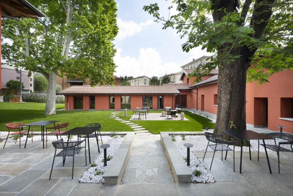 un patio con mesas, sillas y un árbol en Villa Il Platano, en Como