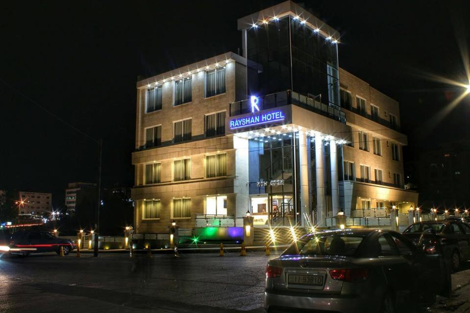 a building with a sign on it at night at Hotel Rayshan in Amman