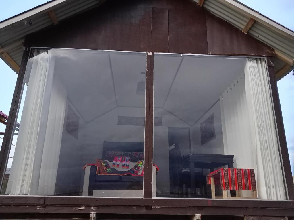 a window of a house with a table and chairs at Q'OTA TAYPY LODGE in Puno