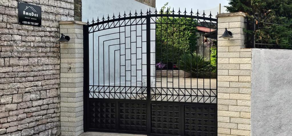 een ijzeren poort in een gebouw met een oprit bij Guest House AmaDes in Gjirokastër