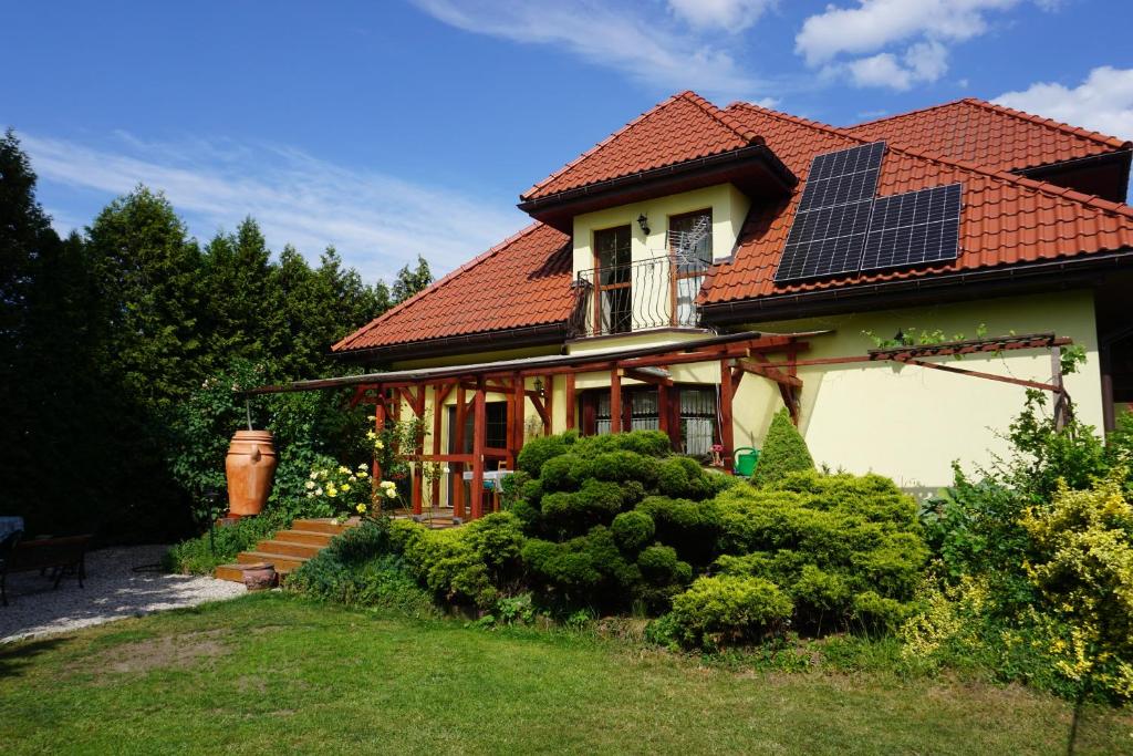 MańkiComfortable house with garden的屋顶上设有太阳能电池板的房子