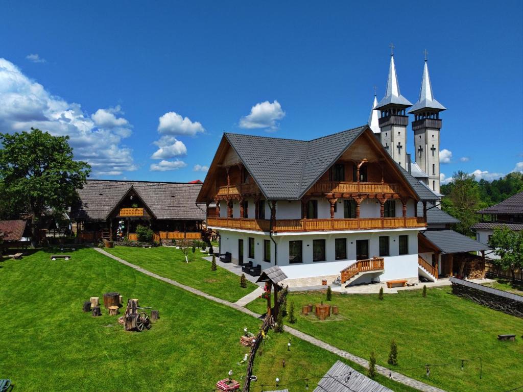 un grand bâtiment avec un château en arrière-plan dans l'établissement Pensiunea Maramu, à Breb