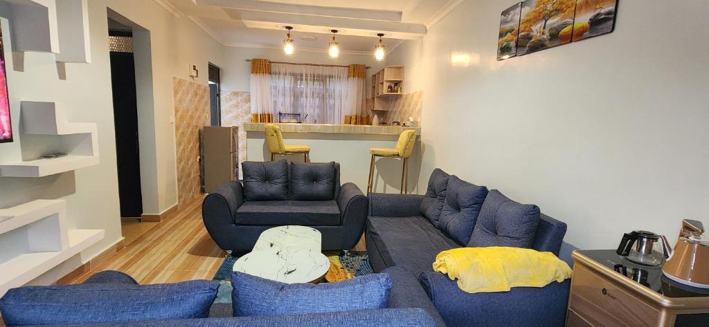 ein Wohnzimmer mit einem blauen Sofa und 2 Stühlen in der Unterkunft Neim Homes in Meru