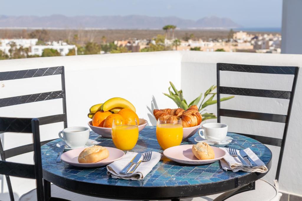 un tavolo con colazione a base di pane e succo d'arancia di El balcón del Cabo a Almería