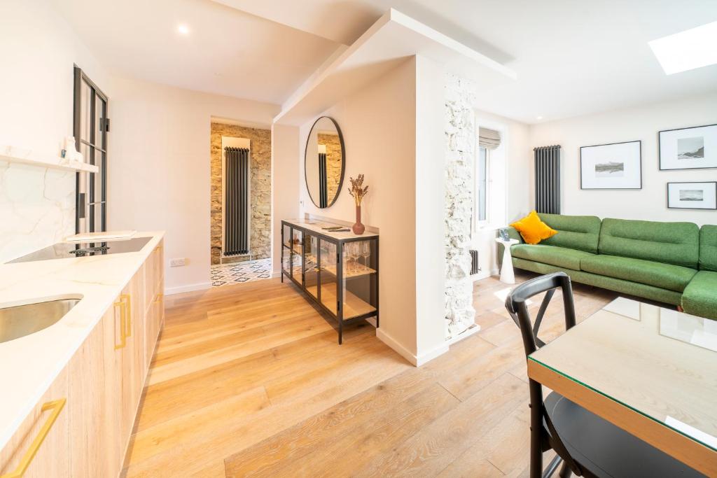 Il comprend une cuisine et un salon avec un canapé vert. dans l'établissement Boutique Townhouse, à Westport