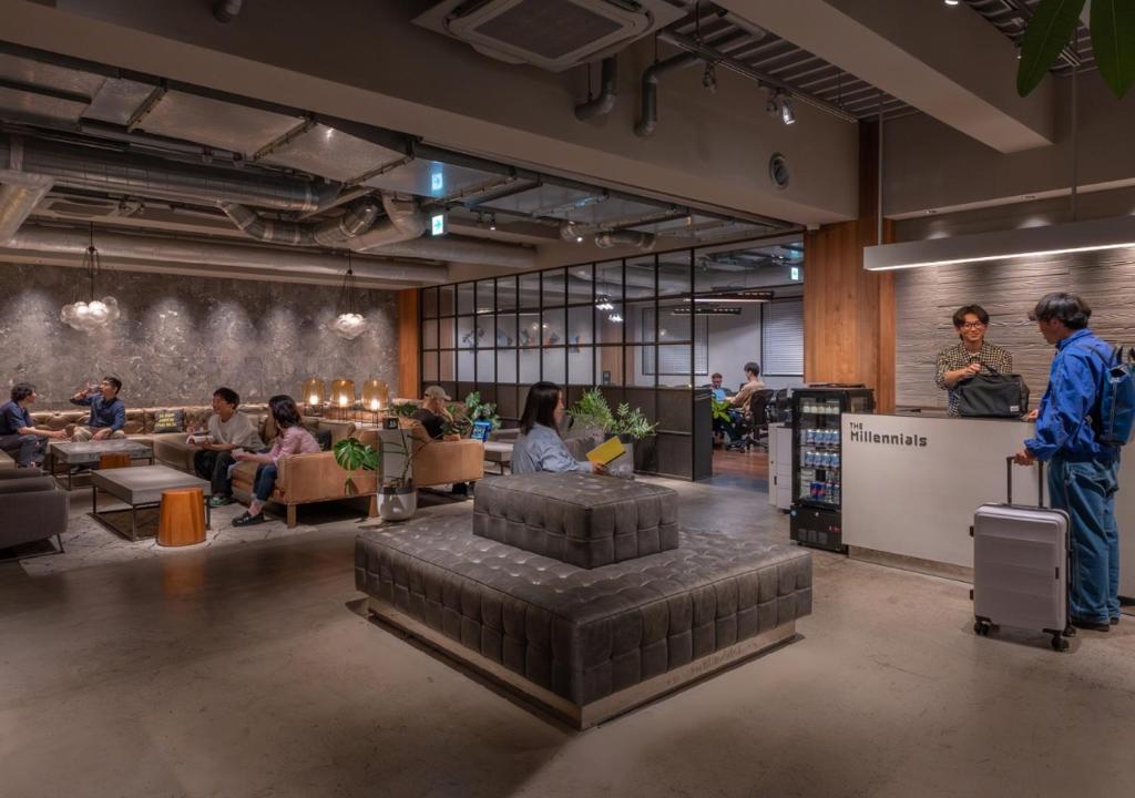 a group of people sitting in a large room at The Millennials Kyoto in Kyoto