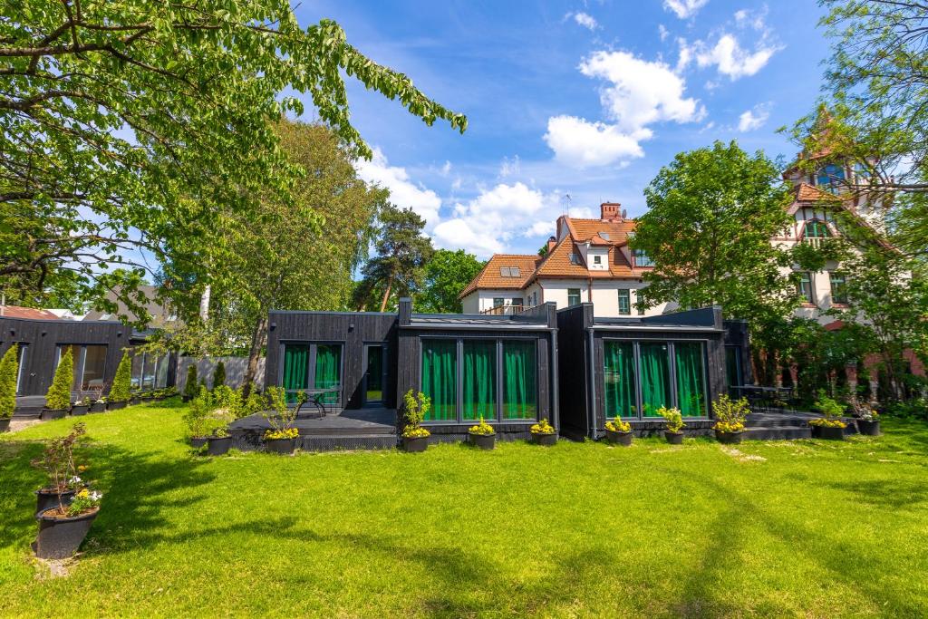 ein Haus mit grünen Türen im Hof in der Unterkunft Baltic Beach Houses & Jomas in Jūrmala