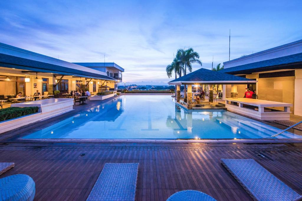 uma grande piscina num edifício com um resort em L'Fisher Hotel Bacolod em Bacolod