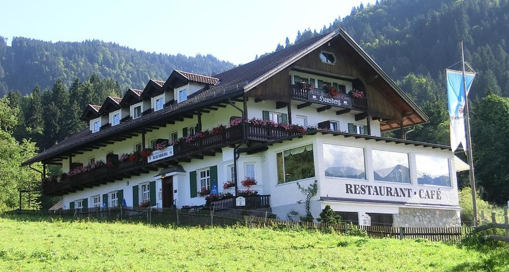 un edificio en una colina en un campo en Hotel Restaurant Hausberg Garmisch-Partenkirchen, en Garmisch-Partenkirchen